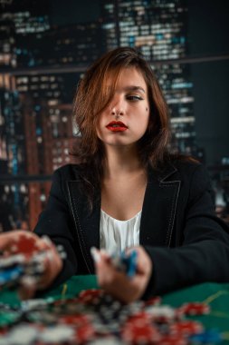 Kadın oyuncu para için fiş sayar ve kumarhanede poker oynarken bahsi artırır. Kumar konsepti. Kadın ve poker. Elbiseli bir kadın.