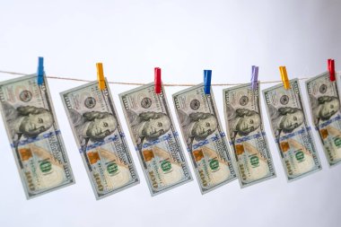 Gride izole edilmiş bir ipte 100 dolar asılı. Çamaşır yıkamama kavramı. 