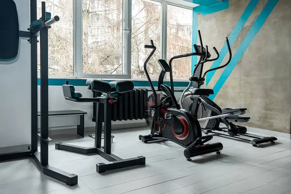 modern light gym with simple bright rooms awaits customers. Sports equipment in the gym. Bars of different weights on the rack.