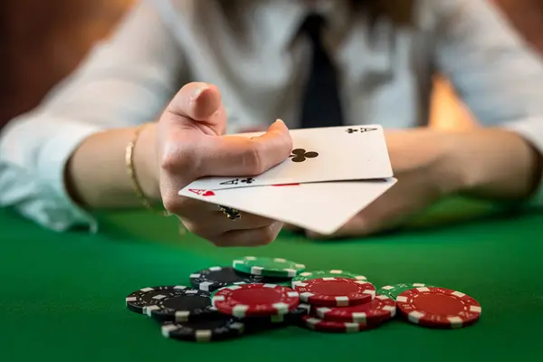 professional poker player woman makes a move with cards and chips at the table. isolated on plain background. poker. casino. excitement