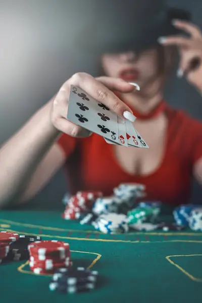 poker player sits at a poker table with cards in her hands and poker chips on the table. poker. casino