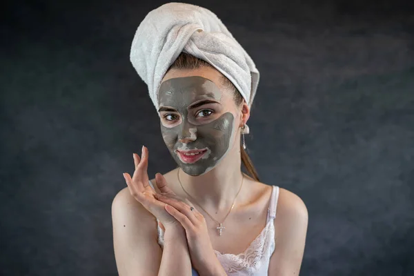 Green beauty clay mask on female face isolated on black. Skin care, anti aging treatment