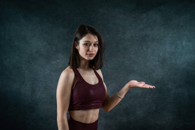 Stüdyoda siyah üzerine izole edilmiş spor sutyen giyen genç, ince kadın fitness eğitmeni. Spor sağlığı.