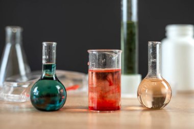 Laboratuvarda renk sıvısıyla deney yapmak için laboratuvar mataraları ve deney tüpleri. Kimyasal araştırma