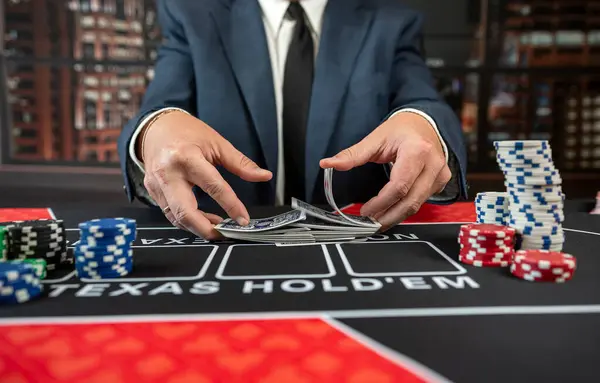 Man croupier holding playing cards before start game poker at casino. Texas holdem, gambling concept