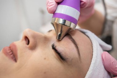 Kozmetik uzmanı, kaplıcada gençleştirme için yüzüne ultrason yapıyor. Yüz derisi genç ve sağlıklı.