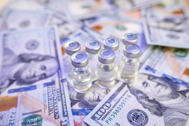 Coronavirus aşısı ya da şişedeki diğer maddeler dolar kağıtları üzerinde, aşı kavramı ve Coronavirus 'a karşı tedavi, eczane çok pahalıdır. 