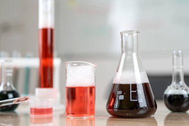 Laboratuar masasında renkli sıvılar olan kimyasal şişeler. Teknoloji bilimi 