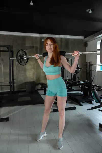 red-hair fitness woman lifts barbell in gym. Healthy lifestyle. Sport for everythin