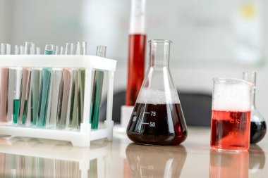 Laboratuvarda renk sıvısıyla deney yapmak için laboratuvar mataraları ve deney tüpleri. Kimyasal araştırma