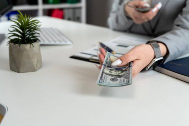 Kadın finans muhasebecisi, ofis işyerindeki kar, finans grafiği ve grafiğini dolar olarak sayar. Bütçe kavramı