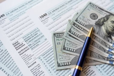 Kalemle birlikte 1040 vergi formu ve masasında dolarlarımız var. Mali konsept