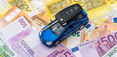 Banknotlarında anahtarlık olan küçük bir oyuncak araba. Satılık kira veya sigorta parası