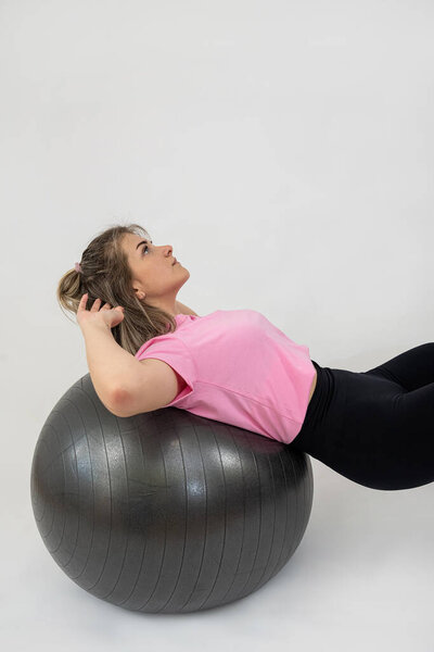 Спортивная женщина делает тренировку на спортзале мяч на белом фоне. Концепция