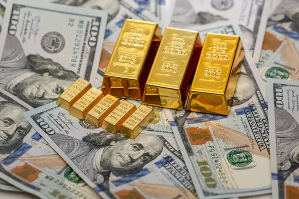 Finance concept gold bullion lie on 100 US Dollar bills background. Investment exchange money