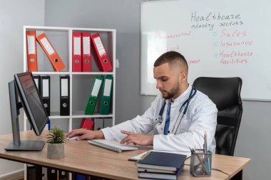 Sağlık hizmetleri kliniğinde teşhis için hastanedeki ofisinde çalışan beyaz bir doktor. Test sonuçlarını analiz et