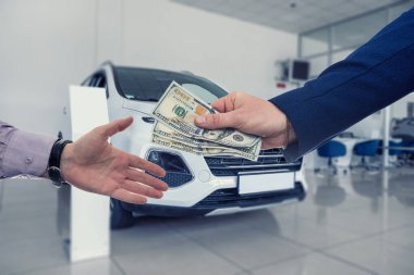 Araba satıcısı ve alıcısı araba galerisinde yeni bir araba almışlar. Arabaları satılan modern bir sergi salonu.