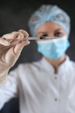 Kadın doktor elinde şırınga tutuyor. İlaç ve uyuşturucu kavramı