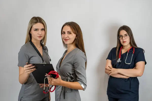 Portrait of a team of woman doctor in uniform at studio, isolated. Health care medical staff concept