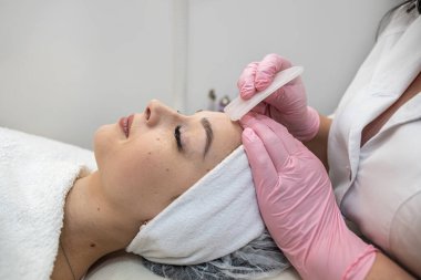 Kozmetikçi masör kadın müşterisi için guaj kazıyıcı ile antiagratik prosedürü uyguluyor. Tedavi, vücut bakımı