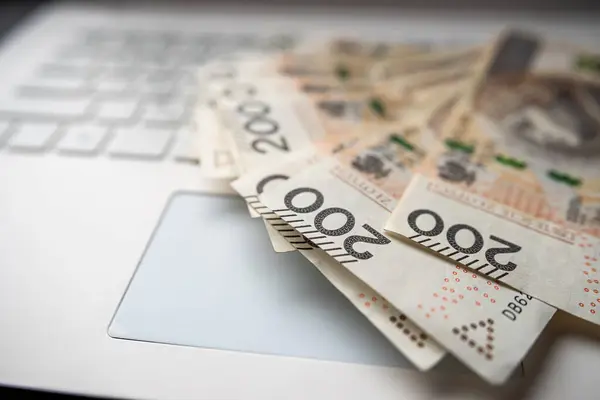 Pln 200 zloty Polish money on laptop keyboard, finance saving concept