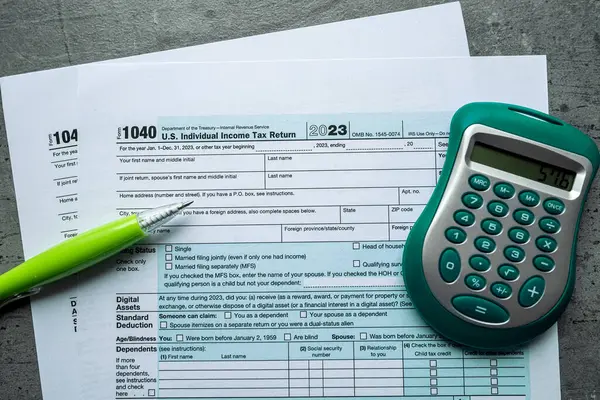 2023 tax return form 1040 with pen and calculator on desk. Tax time, business concept