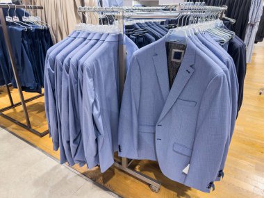 Yeni koleksiyon modern erkek takımları kapanış mağazasındaki askılarda asılı. Yeni sezon yeni satın alma