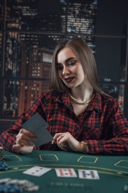 Poker kartları ve fişleri olan kadın poker oynuyor. Poker suratı, kumar anlayışı