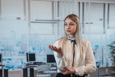 Ofiste duran bayan patron, ellerinin yardımıyla gelecekteki iş planlarını duygusal olarak açıklıyor.