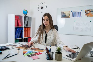 Ofiste, iş yerinde ev çizimi planı üzerinde çalışan profesyonel bir kadın iç mimar. Mavi baskı 