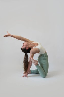 Stüdyo çekimlerinde pilates yapan kadın, gri arka plan. Spor konsepti