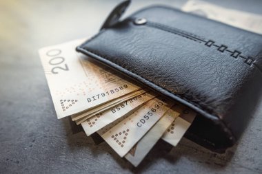 Siyah bir erkek cüzdanında 200 zloti banknot. Ev bütçesi ve finans tasarruf kavramı