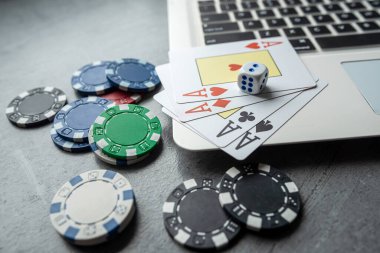 Kumar oynamak için dizüstü bilgisayarında kumarhane fişleri olan poker kartları. Üst görünüm