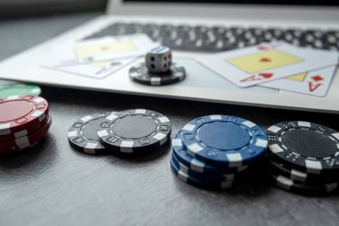  Kumarhane fişleri ve dizüstü bilgisayarda kağıt oynamak. Poker oyunu online konsepti. Kumar.