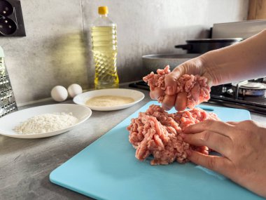 Mutfaktaki kadın, çiğ etten ev yapımı pirzola ya da pelmeni hazırlıyor. Pişmemiş çiğ yemek.