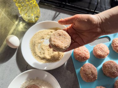 Kadın eli, mutfak masasında çiğ etle köfte hazırlıyor. Pişmemiş yemek.