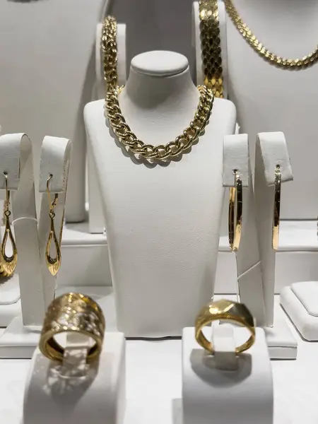 Showcase with luxury golden diamond necklaces, bracelets and earrings in a jewellery shop. Shopping concept