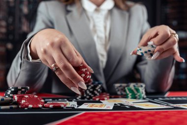 Kadın oyuncu poker oynar ve bahsi arttırmak için fiş alır. Kumarhane oyunu