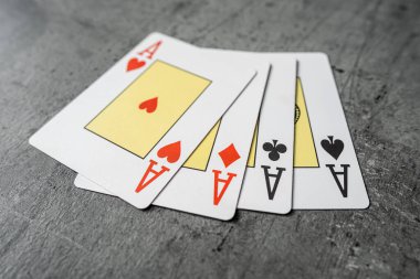 Gri masada kağıt oynayan dört as. Kumar konsepti