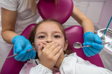 Dişçi, diş kliniğinde korkmuş bir çocuğa diş dolgusu yapacak. İşyerinde diş aletleri kullanan bir doktor. Sevimli bebek hasta diş ağrısı çekmekten korkuyor.. 