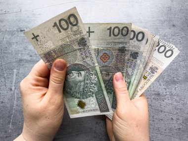 Kadın, 100 pln zl 'lık banknotları tutuyor. Kadın çok para gösteriyor.