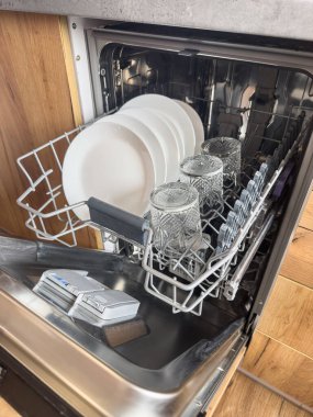 Modern bir bulaşık makinesinde temiz tabaklar ve bardaklar. Ev işleri, günlük yaşam.