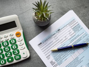 Tahta masadaki vergi muhasebe kağıdı, kalem ve hesap makinesi. Vergi mevsimi