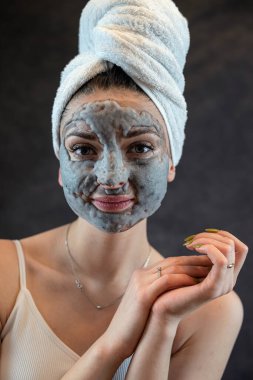 Gri baloncuk maskeli kadın yüzü siyahta izole edilmiş mükemmel cilt için yaşlanma önleyici bir tedavidir. Güzellik merkezi prosedürü