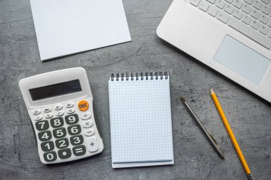 Ofis masası, not defterini, dizüstü bilgisayarı ve hesap makinesini uzaktan çalışma yeri olarak açar. Üst görünüm