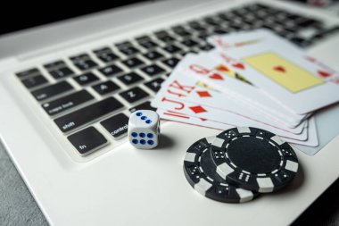 Kumar oynamak için dizüstü bilgisayarında kumarhane fişleri olan poker kartları. Üst görünüm