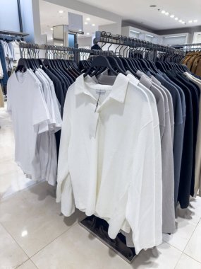 Yeni koleksiyoncu gömlekleri üst üste asılıyor. Modern moda kıyafetler.