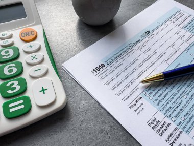 Tahta masadaki vergi muhasebe kağıdı, kalem ve hesap makinesi. Vergi mevsimi