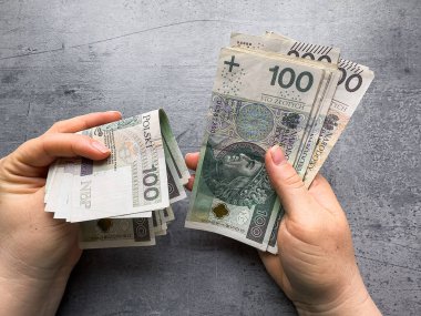 Kadın, 100 pln zl 'lık banknotları tutuyor. Kadın çok para gösteriyor.