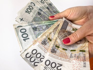 Kadın elinde bir sürü Polonya 100 Zloti banknotu var.